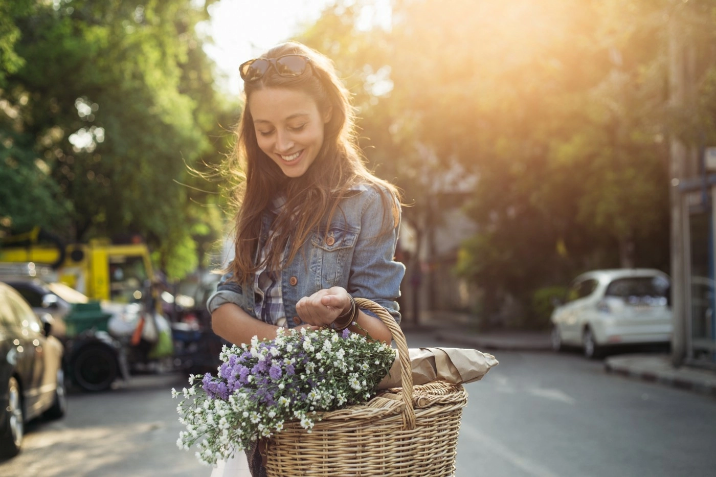 Woman smiling, crossing the street holding a basket of flowers