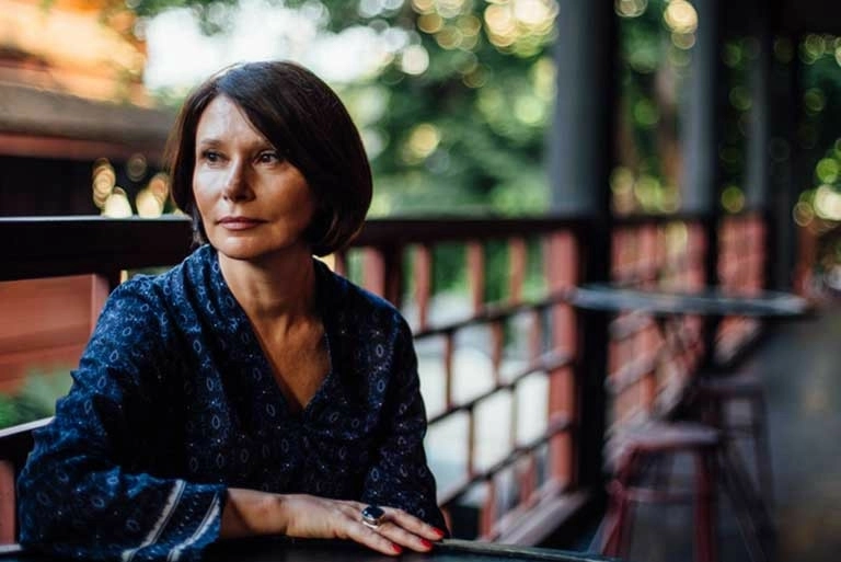 A woman sitting on a porch gazing into the distance