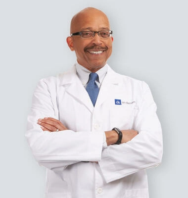 Doctor with arms crossed in front of white wall