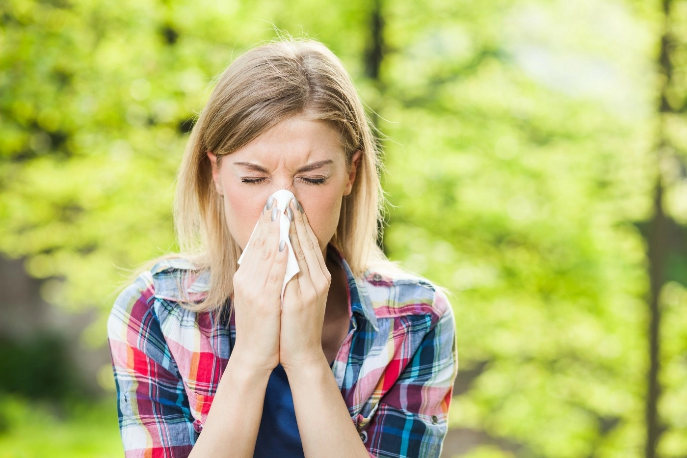 A woman sneezing into a tissue