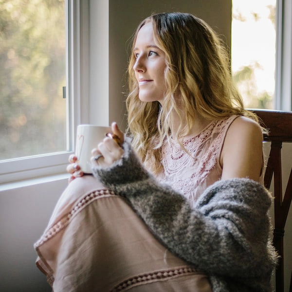 young woman sitting and looking out window