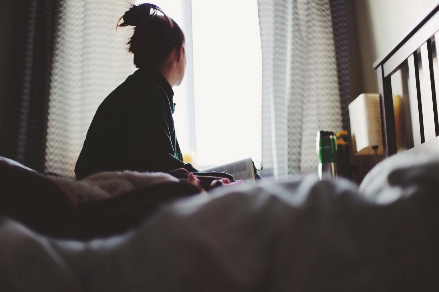 person concerned looking out the bedroom window
