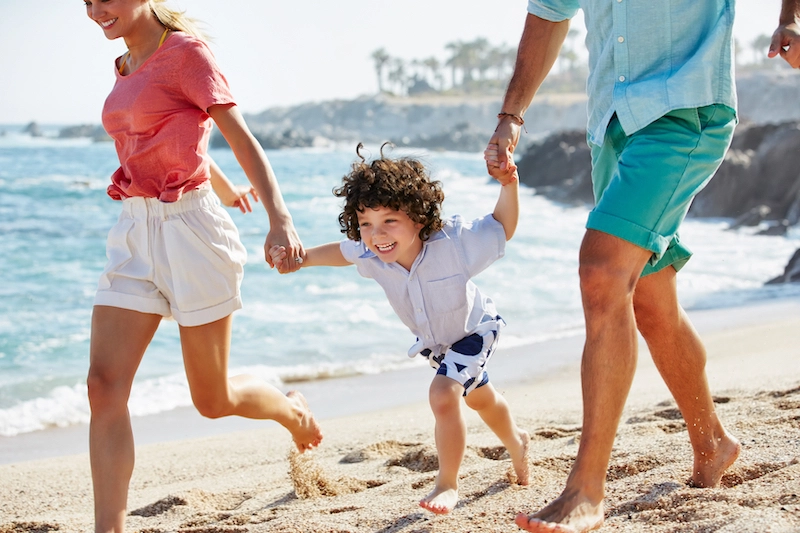 Family walking and laughing on beach