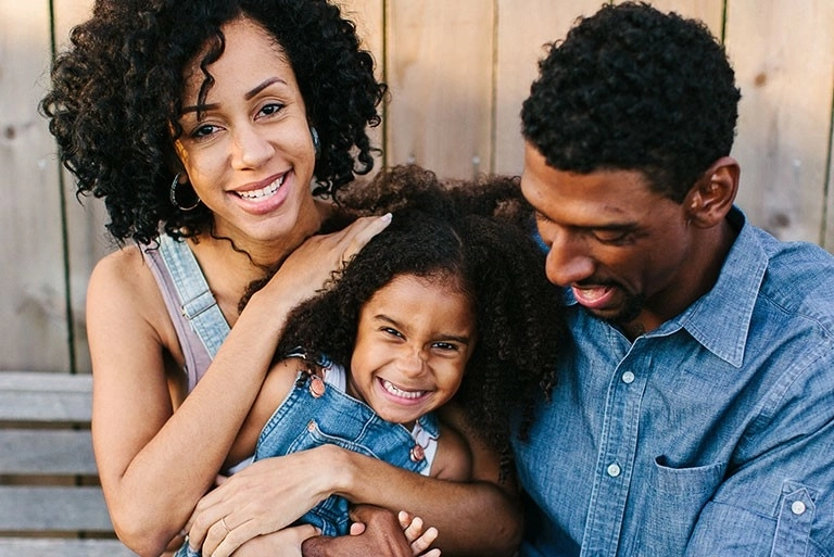 mom and dad and small child laughing