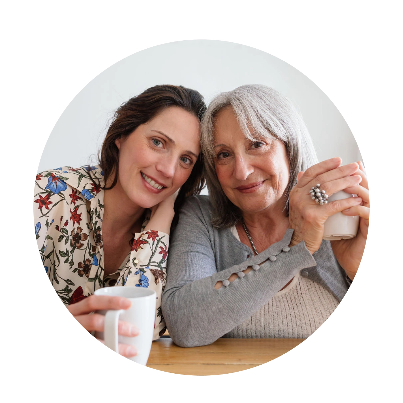 two woman smiling with heads leaning on each other