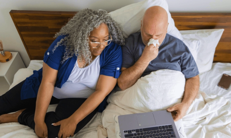 husband and wife using Doctor On Demand sick from their bed.
