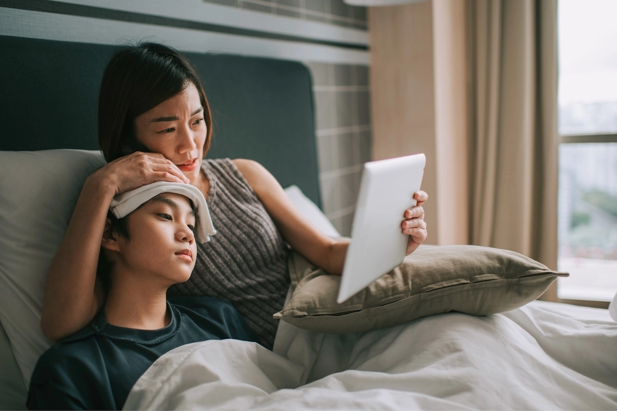 mom and sick in bed using Doctor On Demand urgent care telehealth