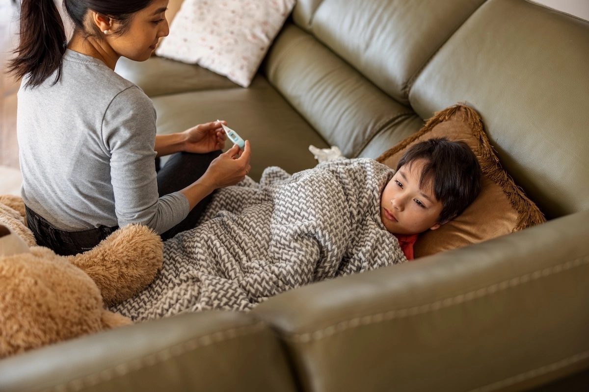 mom taking care of sick child on couch