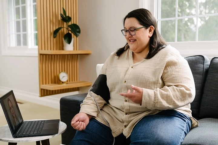 woman taking blood pressure at home for teleheatlh visit