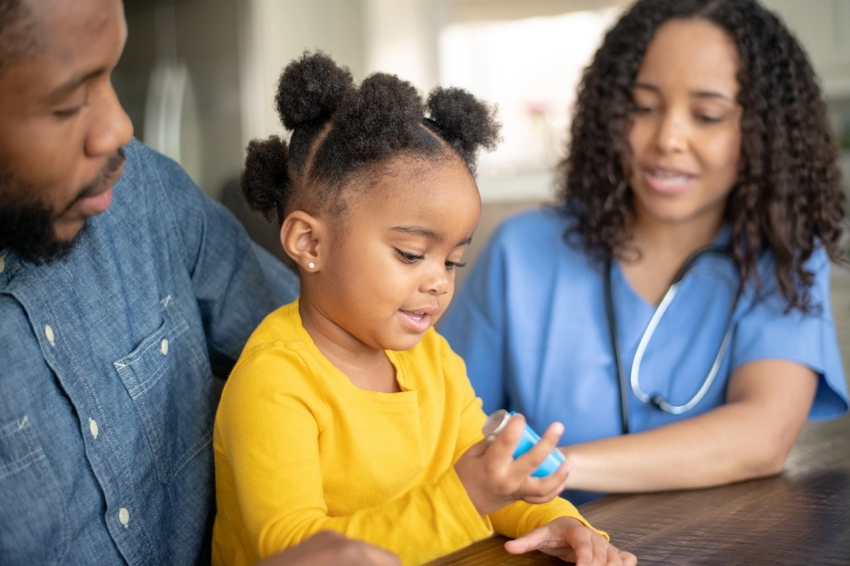 parents with little daughter who is holding her asthma inhaler
