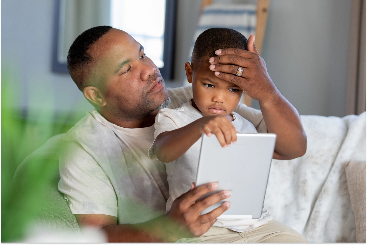 Father checking son on forehead to see if he has a fever