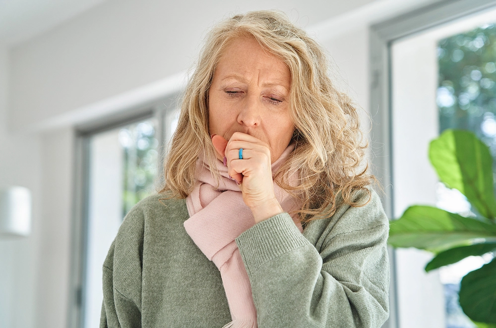 woman coughing into her hand
