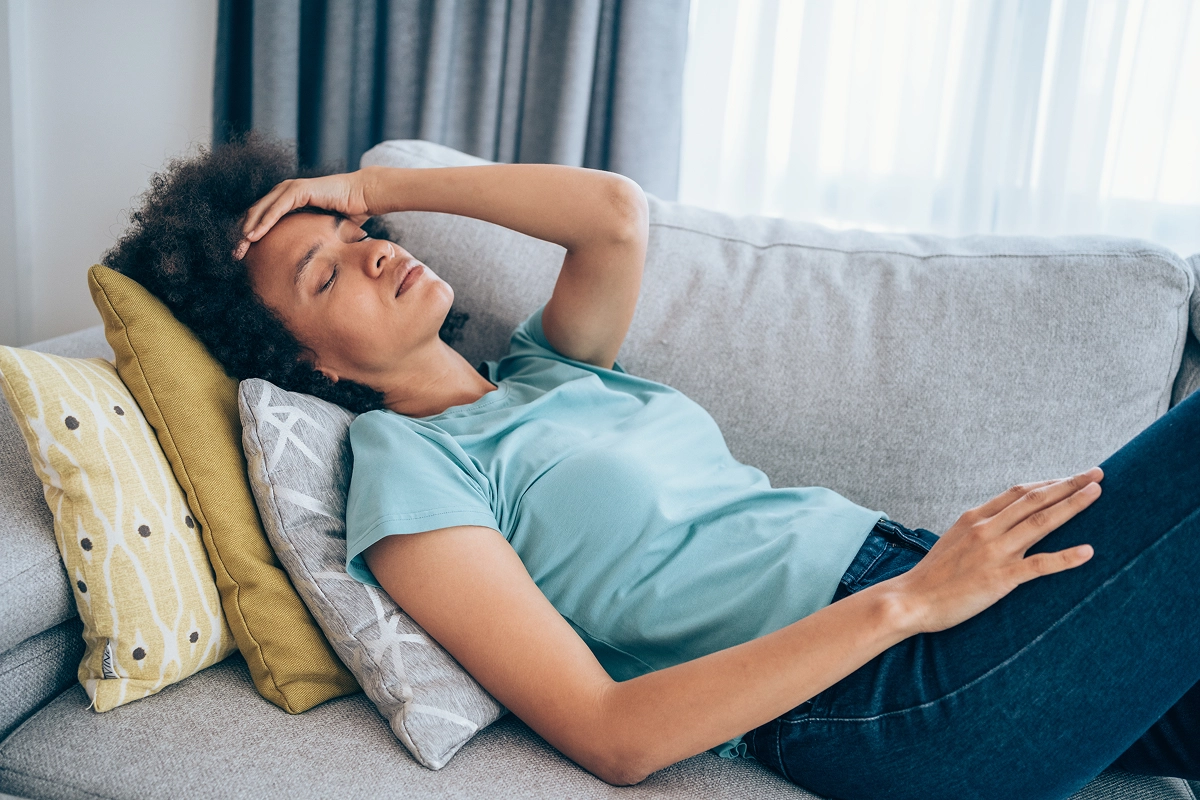 Woman lying on a couch with pain from a yeast infection