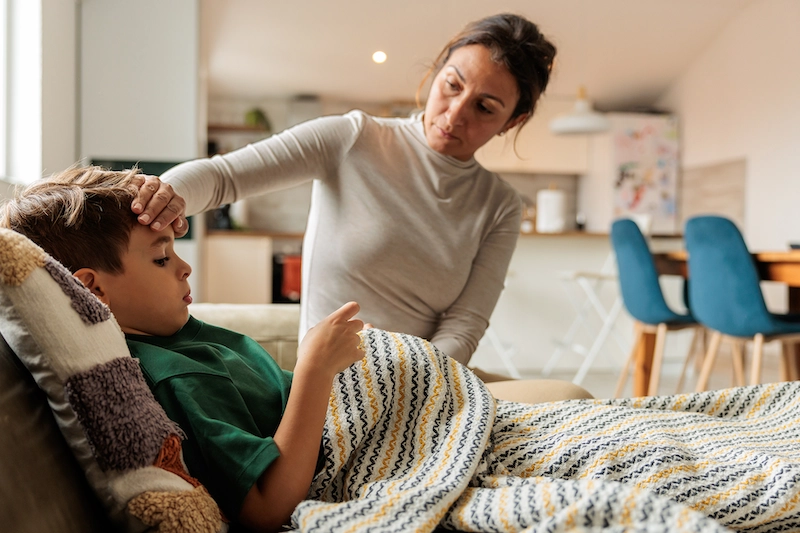 Mother checking son's temperature
