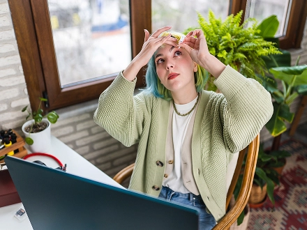 Woman putting in eyedrops for allergies