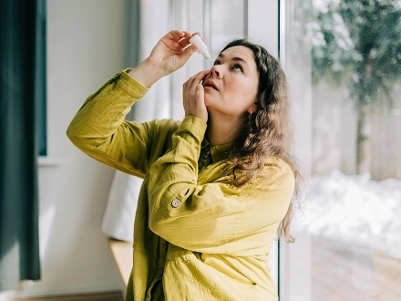Woman putting in eye drops for pink eye