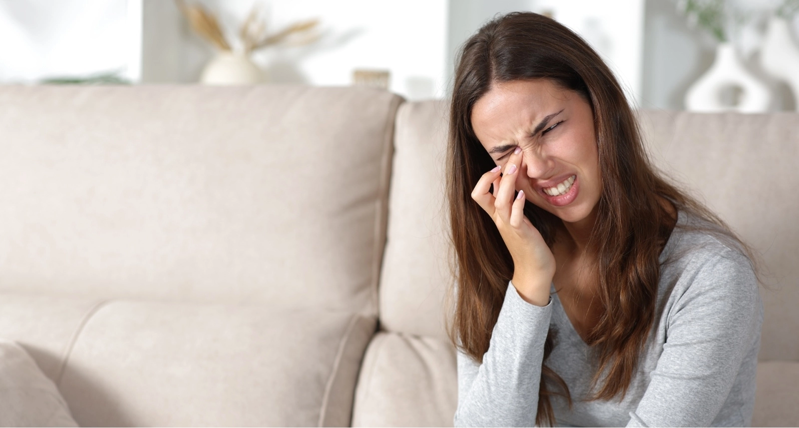 Woman with pink eye rubbing her eyes