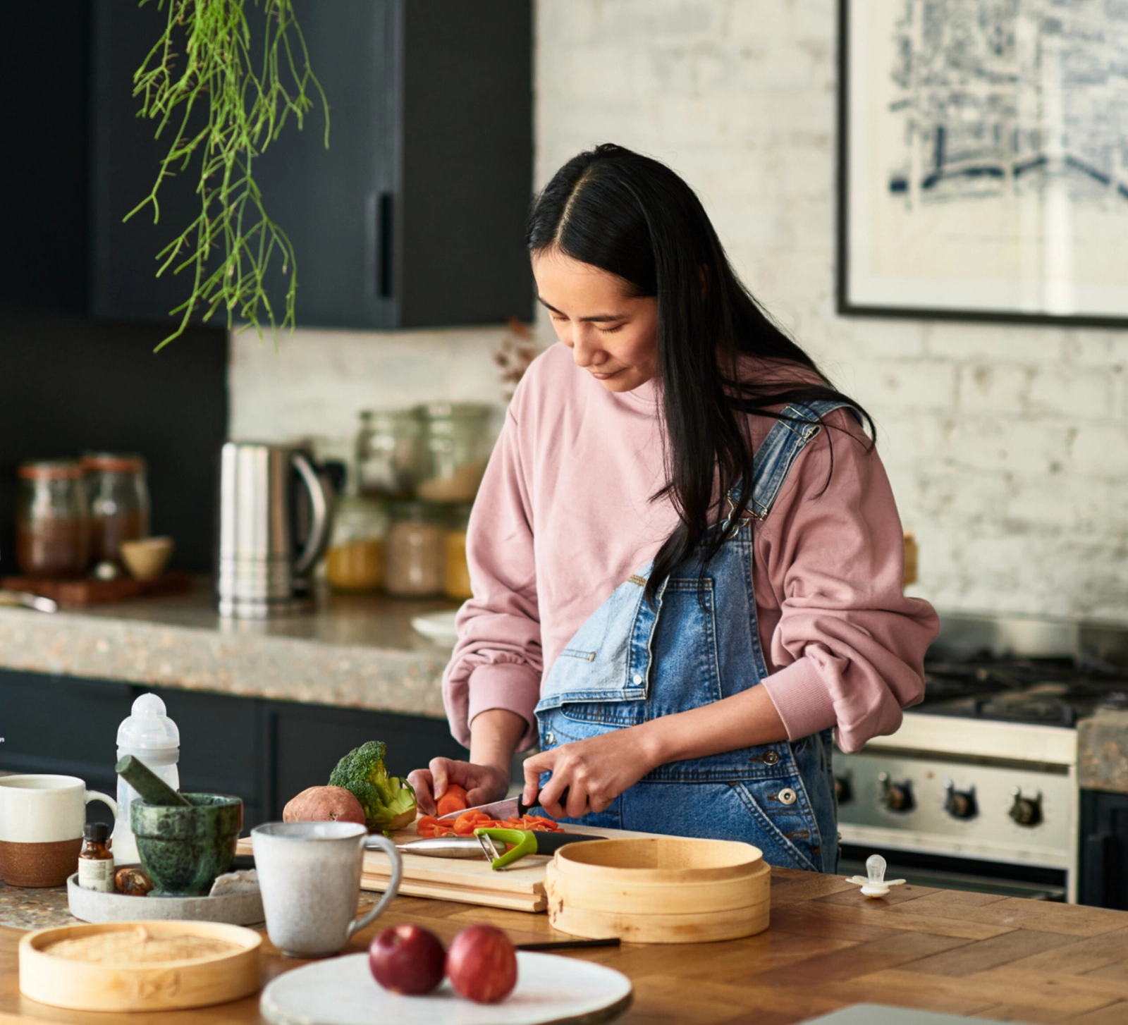 A woman cutting vegetables in her kitchen.
