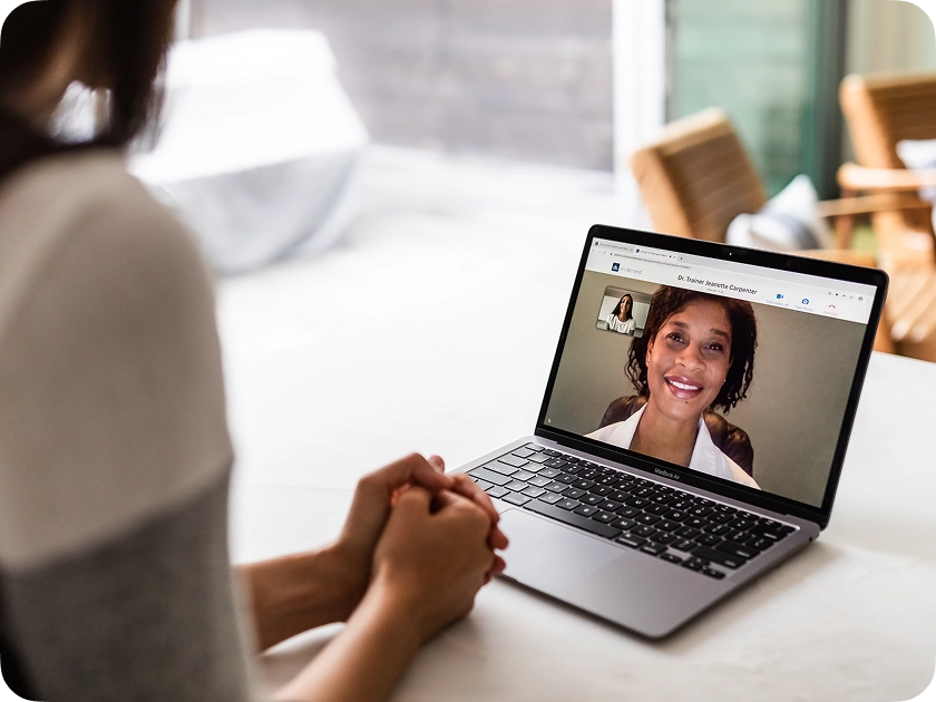 A woman speaking with a doctor on her laptop.