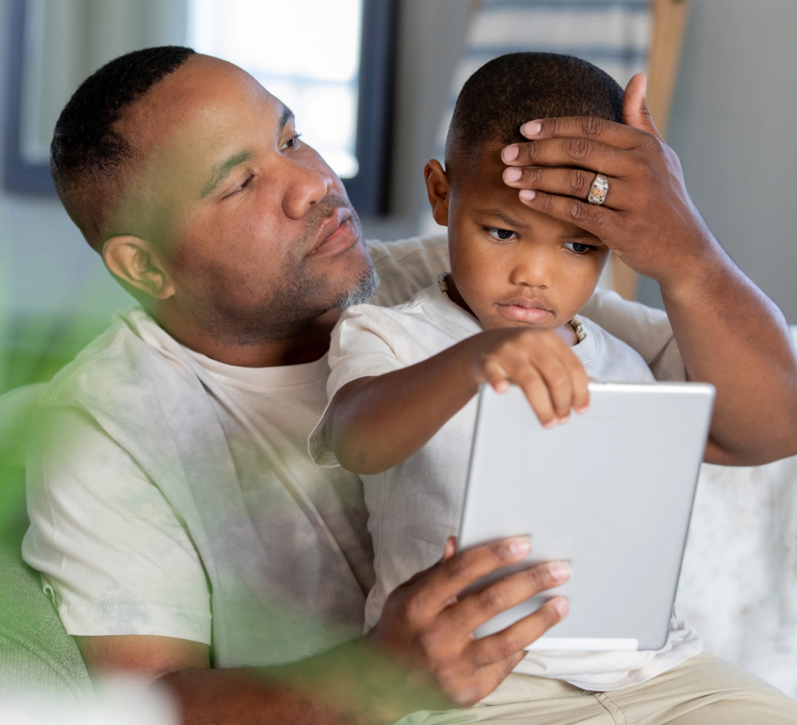A father checking his son's temperature.