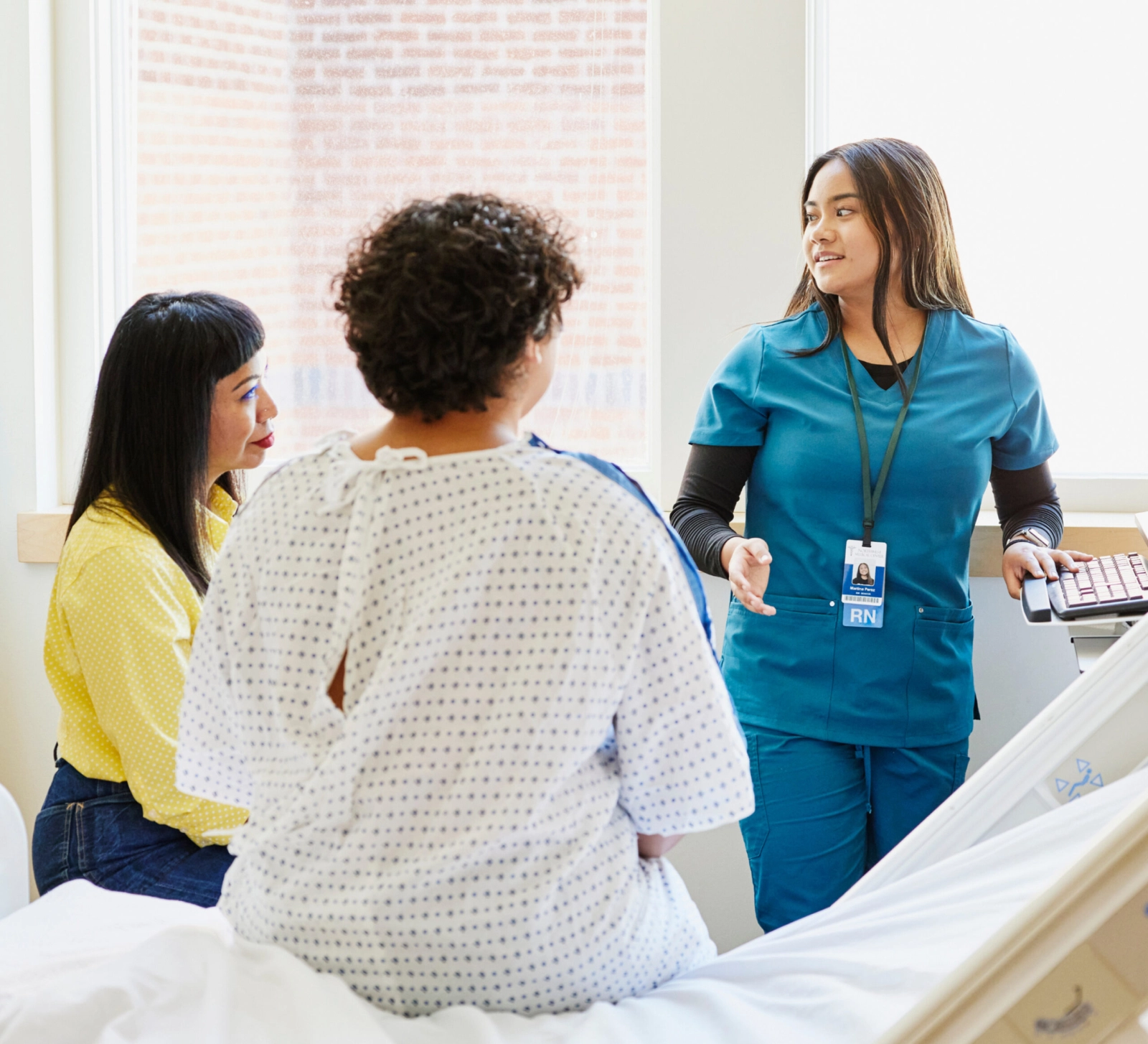 A nurse speaking with a patient in a recovery room.