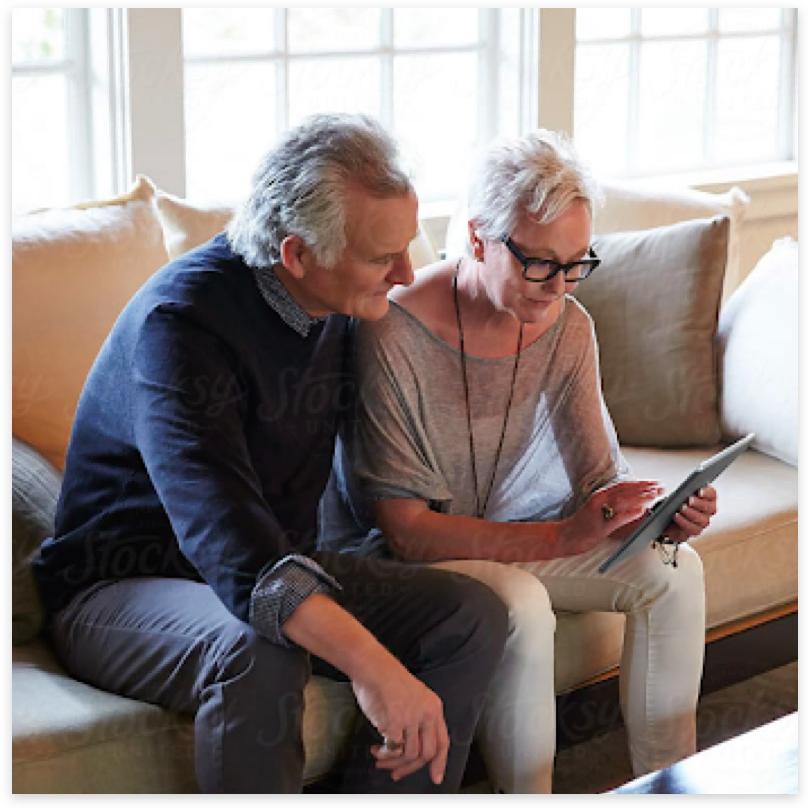 Couple sitting on sofa with tablet
